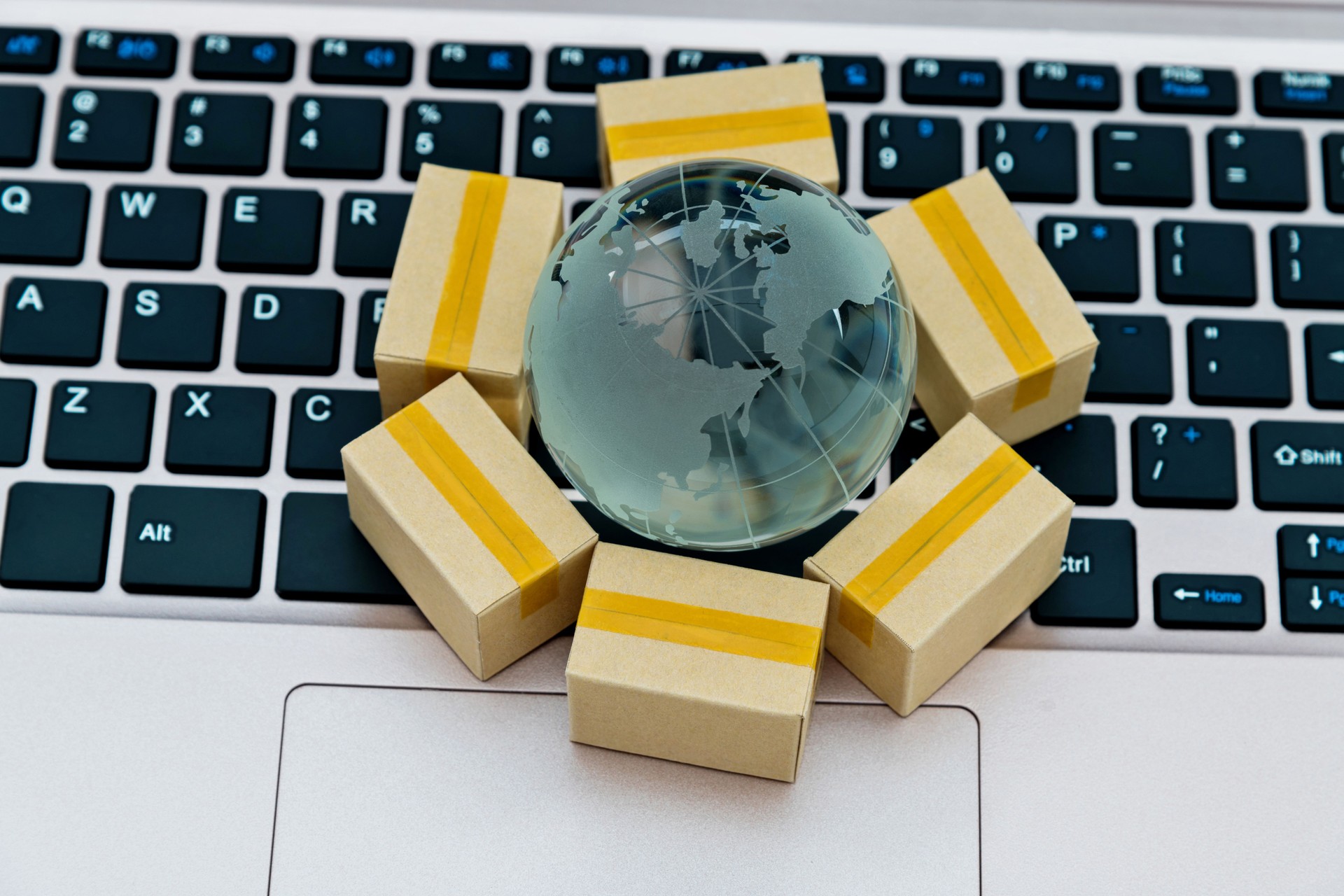 Glass globe  and small boxes on laptop keyboard